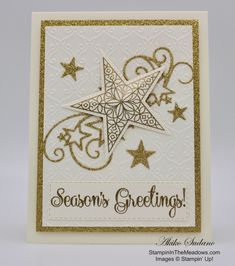 a white card with gold foil stars and the words season's greetings