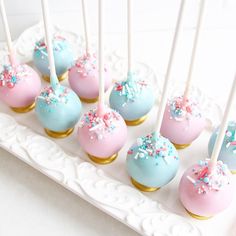 cake pops with sprinkles and blue frosting on a white platter