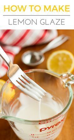 a glass measuring cup filled with lemonade next to a metal fork and spoon on top of a wooden table