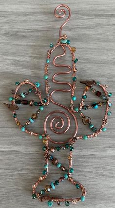 a wire sculpture with beads and charms on it