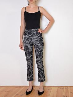 Cool vintage pants made of a bit stretchy, thinner denim-like fabric. Black with large print of leafs outline. Mid-waisted slim fit with cropped legs. Button and zip closure. One small pocket on the front. Era: 90's, made in Italy Fabric: 78% cotton, 26% polyamide, 2% elasthane Condition: very good, slightly washed off Estimated size: S /XS (please, check the measurements) Measurements (measured flat, need to be doubled to get the circumference): Waist: 33 cm / 13 inches, has a little bit of str Trendy Fitted Jeans With Graphic Print, Fitted Pants With Graphic Print For Spring, Fitted Black Bottoms With Graphic Print, Fitted Graphic Print Bottoms For Spring, Spring Stretch Pants With Graphic Print, Spring Fitted Bottoms With Graphic Print, Spring Fitted Graphic Print Bottoms, Stretch Pants With Graphic Print For Summer, Y2k Style Tight Graphic Print Bottoms