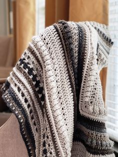 a crocheted shawl draped over a chair