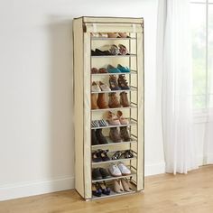 an over the door shoe rack holds many pairs of shoes and is in front of a window