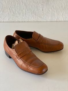 Vintage men's Florsheim shoes from their Designer Collection.  Square toe style in caramel brown leather with leather soles.  Very good vintage with creasing and moderate wear to the soles.  Minor scuffs here and there. 10 7/8" exterior heel to toe 1 1/4" heel height 3 1/2" ball of foot 1980s Glass Bottoms Men Dress Shoe, Retro Brown Loafers With Round Toe, Retro Brown Round Toe Loafers, Vintage Brown Loafers With Round Toe, Vintage Brown Round Toe Loafers, Retro Leather Slip-on Shoes, Retro Brown Wingtip Leather Shoes, Retro Leather Loafers With Leather Sole, Retro Leather Slip-on Loafers