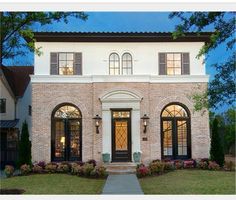 a white brick house with black doors and windows