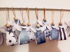 some ornaments are hanging on the wall with clothes pins and tags attached to each ornament