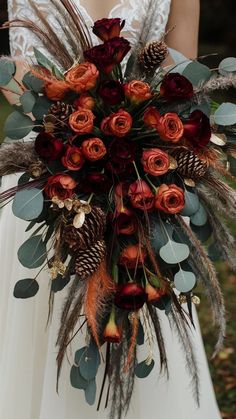 a bridal bouquet with red roses and feathers