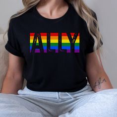 This Ally shirt with ally printed over pride colors tshirt is perfect any ally during pride month and all year.  If you desire an oversized look we recommend sizing up one or two sizes.  Bella + Canva Brand Jersey Shirts ■Unisex adult sizing ■100% Airlume combed ringspun cotton for solid colors ■Cotton and polyester blend for heathered colors ■Light fabric 4.2 oz ■Tear Away Label ■Retail fit ■Size up one or two sizes for a more oversized fit PRINT ■This item is printed using DTG (direct to garme Pride Shirt Ideas, Pride Outfit Ideas Women, Ally Shirt, Lgbtq Support, Lgbtq Ally, Theatre Shirts, Pride T Shirt, Gay Pride Shirts, New Teacher Gifts