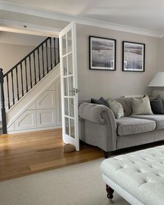 a living room filled with furniture next to a stair case