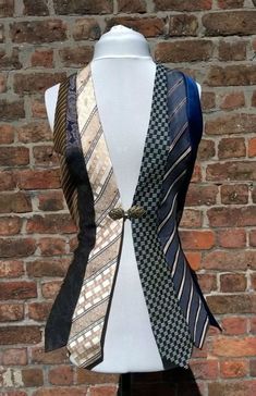 a white mannequin wearing a black and gold neck tie on it's chest