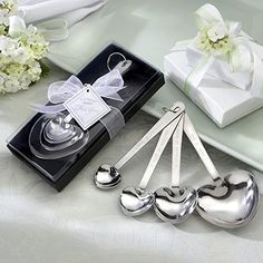 four spoons and two forks are sitting on a table next to a gift box