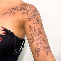 a woman's arm with flowers on it and a ring around the wrist tattoo