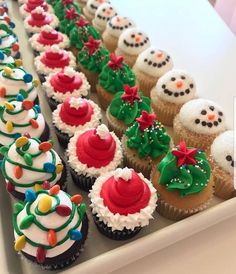 cupcakes with frosting and decorations are lined up on a tray