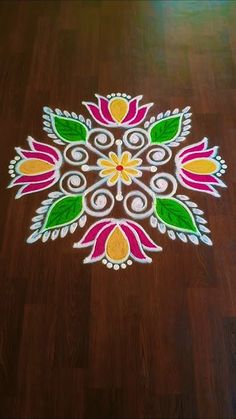 a colorful flower design on the floor in front of a wooden floor with white and yellow colors