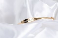 We call her perfect because once we perfected the sample for this bangle, we didn't take her off for 2 years. Fancy, but not too fancy. Just the right shape. Just the right width. The one thing you'll always wear. Solid 14k gold bangle with your name, text or bespoke design Engravable on front and inside Hand engraved to order The Perfect Bangle Sizing Small: 6.3in circumference; 52.10mm x 50.25mm diameter Medium: 6.8in circumference; 56.00mm x 54.00mm diameter Large: 7.2in circumference; 60.00m Elegant Rose Gold Name Bracelet For Formal Occasions, Elegant Engraved Rose Gold Bracelet, Elegant Hallmarked Cuff Bracelet For Anniversary, Adjustable Elegant Name Bracelet With Engraving Option, Elegant Adjustable Name Bracelet With Engraving Option, Elegant Gold Bracelet With Polished Finish For Anniversary, Wedding Fine Jewelry Cuff Bracelet With Polished Finish, 14k Rose Gold Cuff Bracelet For Wedding, Elegant Polished Gold Bracelet For Anniversary