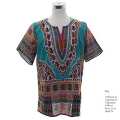 Seventies reproduction Dashiki shirt (teal background, short sleeve). Classic 70s hippie shirt style in shades of shades of rust, lavender, gold, black and white. Two lower patch pockets, large side slits at hemline. Fits 42 to 44 Chest (Men's large or Womens XL). Lightweight cotton fabric, wash separately and tumble dry briefly on low. New, unworn. Longer tunic style fit. Our item # 361827 Blue Short Sleeve Shirt For Festival, Fitted Multicolor Bohemian Shirt, Hippie Patterned Short Sleeve Tops, Bohemian Brown Shirt For Summer, Green Bohemian Summer Shirt, Summer Bohemian Green Shirt, Patterned Short Sleeve Hippie Tops, Bohemian Green Shirt For Vacation, Green Bohemian Shirt For The Beach