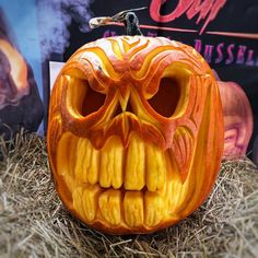 a carved pumpkin sitting on top of hay