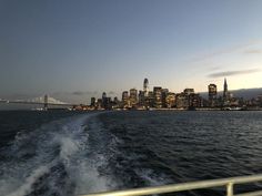 the city skyline as seen from a boat in the water at night with lights on