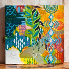 a painting on a wooden surface with an abstract design in the middle and colorful colors