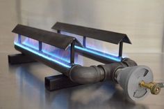 a gas stove with two burners on it's side and the flame is blue