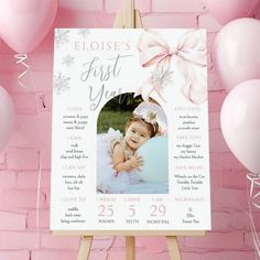 a baby's first year photo on a easel surrounded by balloons and streamers