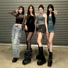 three girls standing next to each other in front of a garage door with one pointing at the camera