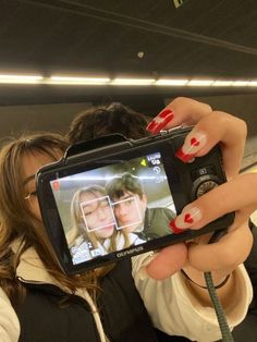 a woman taking a selfie with her cell phone in front of her and another person behind her