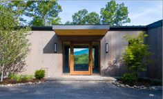 an entrance to a house with trees and bushes