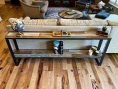 a living room filled with furniture and a wooden table in front of a couch on top of a hard wood floor