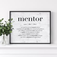 a white fireplace mantle with a black framed sign that says mentor on it and a potted plant next to it