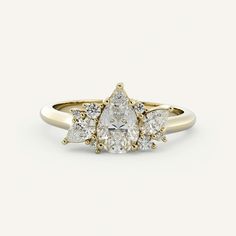 a yellow gold ring with three pear shaped diamonds