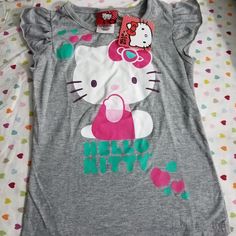 Brand New Playful Hello Kitty T-shirt For Spring, Cute Stretch T-shirt, Cute Hello Kitty T-shirt For Spring, Playful Gray Cotton Tops, Playful Gray Cotton Top, Playful Hello Kitty Tops For Spring, Spring Hello Kitty Playful Tops, Cotton Hello Kitty Fun Tops, Fun Cotton Tops With Hello Kitty