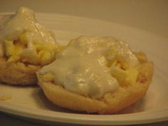 an egg muffin on a white plate with some cream cheese drizzled over it