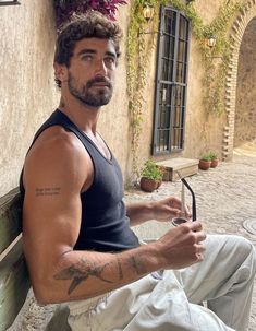 a man sitting on top of a wooden bench