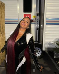 a woman with long hair standing in front of a trailer