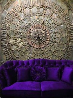 a purple couch sitting in front of a metal wall