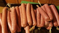 several sausages are lined up on a tray in the kitchen, ready to be cooked