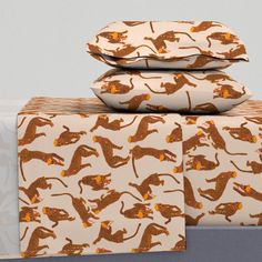 three pillows are stacked on top of each other in front of a white background with gold and orange designs