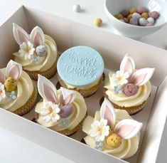 cupcakes decorated with bunny ears and flowers in a box