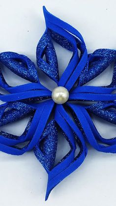 a blue brooch with a pearl in the center