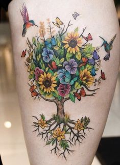 a woman's thigh with colorful flowers and butterflies on the bottom part of her leg