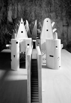 several wooden sculptures sitting on top of a white table next to a black and white wall