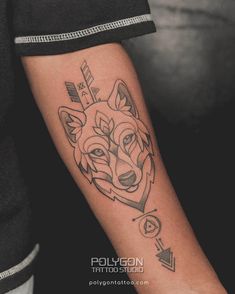 a tattoo on the arm of a person with a wolf head and arrows around it