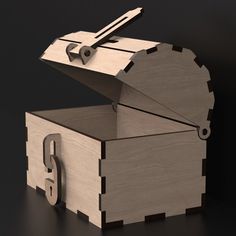 an open wooden box with scissors in it on a black surface, next to the letter g