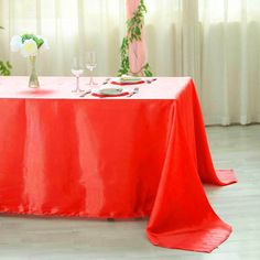 the table is set with red cloths and place settings for two people to sit at