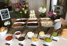 an assortment of food is displayed on a table with bowls and spoons in front of it