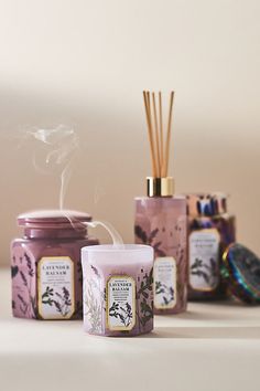 three jars with candles and sticks in them sitting next to each other on a table