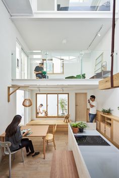 two people are sitting at a table in the middle of an open floor plan kitchen