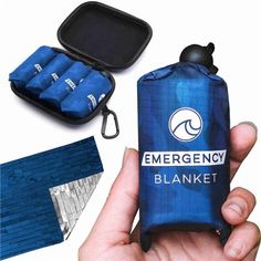 an emergency blanket is being held up in front of it's case and contents