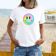 Tie-Dye Smiley Face Retro Aesthetic T-Shirt ﻿The model is wearing white. Despite every effort to provide accurate images of each product and design the colors may vary slightly, due to different device screen settings and photography lighting. Please be aware that our clothes are not oversized. If you desire an oversized look we recommend ordering 2-3 sizes larger than how you size on our size guides. Classic Fit 100% Cotton Preshrunk jersey knit Seamless double-needle 7/8" collar Taped neck and White Printed Casual T-shirt, Casual White Printed T-shirt, Summer Tie Dye T-shirt With Funny Print, Fun White T-shirt With Sublimation Print, Trendy Tie Dye T-shirt With Graphic Print, Casual Multicolor T-shirt With Funny Print, Casual Tie-dye Printed T-shirt, Casual Tie Dye Printed T-shirt, Casual Printed Tie Dye T-shirt